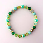 A green and gold beaded bracelet with iridescent green beads