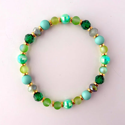 A green and gold beaded bracelet with iridescent green beads
