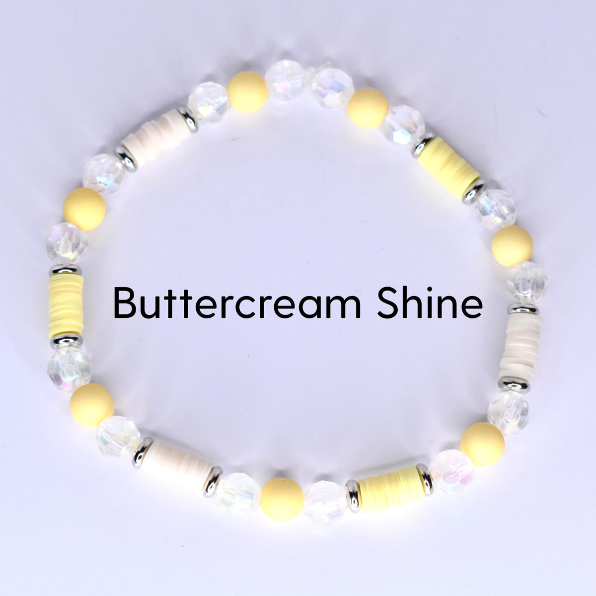 A beaded bracelet with the text "Buttercream Shine". The bracelet features a mix of yellow, white, and clear beads. The beads are arranged in a circular pattern, creating a stylish accessory.