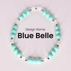 A single bracelet named "Blue Belle" displayed in a circular shape on a light background, made of matte turquoise beads, small silver spacer beads, and clear faceted beads. The design name is centered in bold black text.