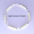 A bracelet with light lemon cream-colored beads and iridescent crystal accents. The bracelet has small silver-colored spacers between the crystal and cream-colored beads. The text "Light Lemon Cream" is displayed.