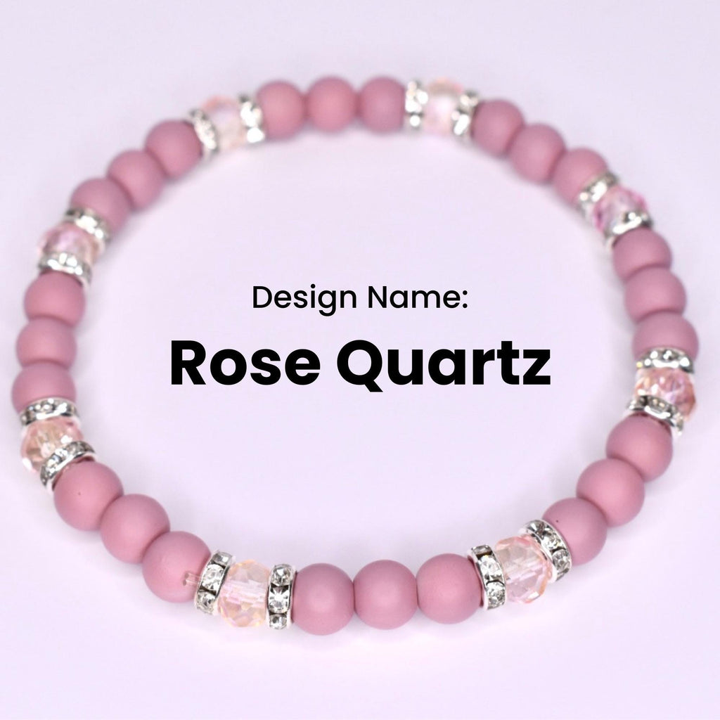 A pink Rose Quartz bracelet with alternating round beads and crystal-studded silver accents. The design name 'Rose Quartz' is displayed in bold black text against a white background. The bracelet is a stretch style.
