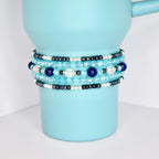 Blue and silver beaded tumbler bracelets wrapped around a metallic blue tumbler, showcasing layered textures and sparkle.