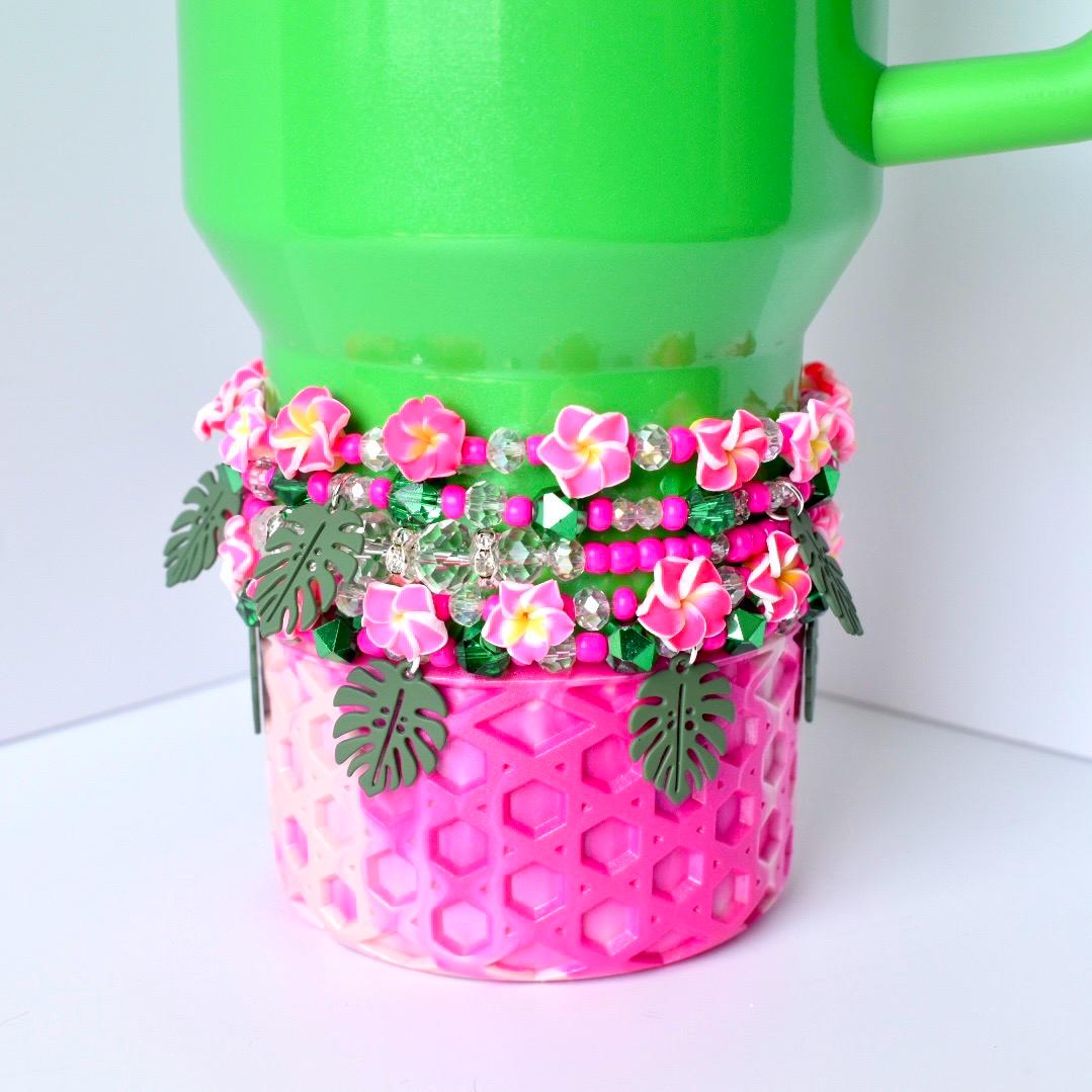 Stack of 5 handmade tumbler bracelets featuring pink flowers, sparkly green beads, pearl accents, and green monstera leaves—perfect tropical tumbler decor for summer vibes.