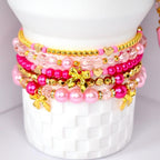 Stacked pink tumbler bracelets with gold bow charms, pink pearls, and clear crystal beads – kawaii tumbler jewelry set.