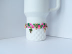 Colorful stackable bracelets featuring bright pink, green, and gold beads, rhinestone spacers, and playful palm charms, draped over a white mug for a chic display.