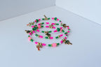 Set of colorful palm tree charm bracelets laid out in overlapping loops, featuring bright pink and green beads, gold spacer beads, and clear faceted crystals for a tropical vibe.