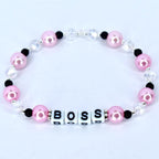 Pink pearl boss bracelet with black and clear crystal beads and white letter beads spelling BOSS handmade gift for boss or coworker.