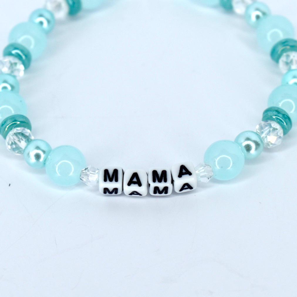 A light blue beaded bracelet with the word "MAMA" spelled out in white letter beads. The bracelet features a mix of round and faceted beads in shades of blue and clear.