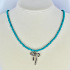 Turquoise seed bead necklace featuring a silver bow pendant – cute trendy handmade necklace.