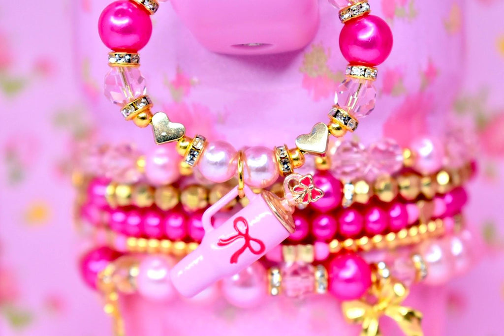 Pink and gold tumbler bracelet set featuring gold bow charms pearls and faceted crystal beads cute girly tumbler accessory.