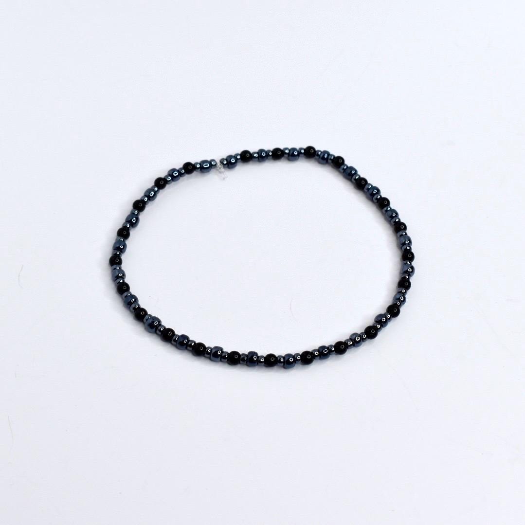 Beaded tumbler bracelet with spider, skeleton hand, and web charms – black and silver Halloween wrap bracelet for gothic drinkware decor.