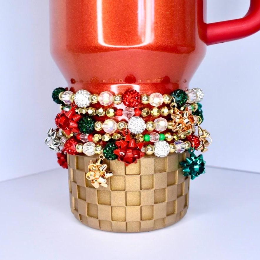 Holiday sparkle tumbler bracelet – red, green, and gold beads with glitter bow charms for Christmas party drinkware accessories.