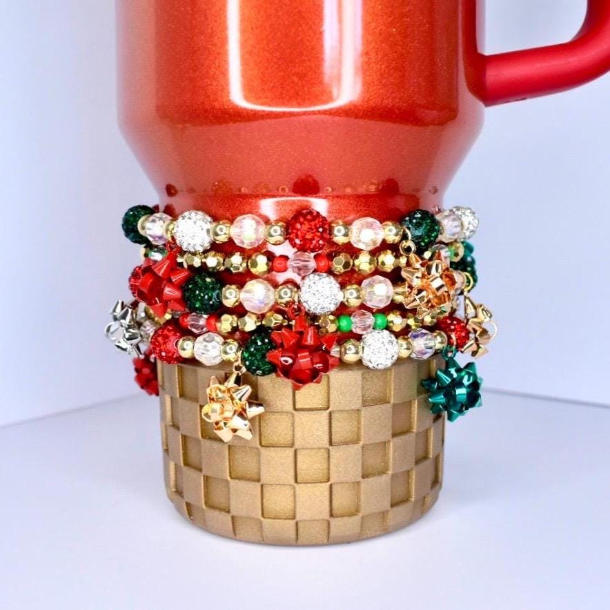 Holiday sparkle tumbler bracelet – red, green, and gold beads with glitter bow charms for Christmas party drinkware accessories.