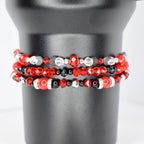 Three beaded bracelets in red, black, and silver. The top bracelet features red and clear beads with black accents. The middle bracelet has red and black beads. The bottom bracelet has red and black beads with silver accents and a large red bead.