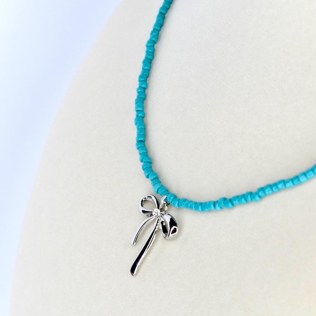 Turquoise beaded necklace with silver bow pendant charm – dainty handmade jewelry gift for her.
