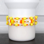 Halloween candy corn tumbler bracelet – yellow, orange, and white beaded wrap with candy corn charms for spooky drinkware accessories.