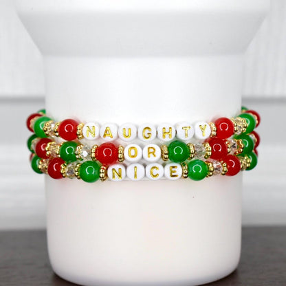 Set of three festive holiday bracelets featuring red, green, and gold beads with Naughty or Nice lettering, perfect for Christmas accessories.