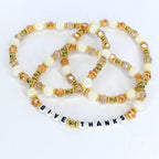 Thanksgiving hostess gift tumbler bracelet – ‘Give Thanks’ beaded wrap in gold and ivory for autumn drinkware accessories.