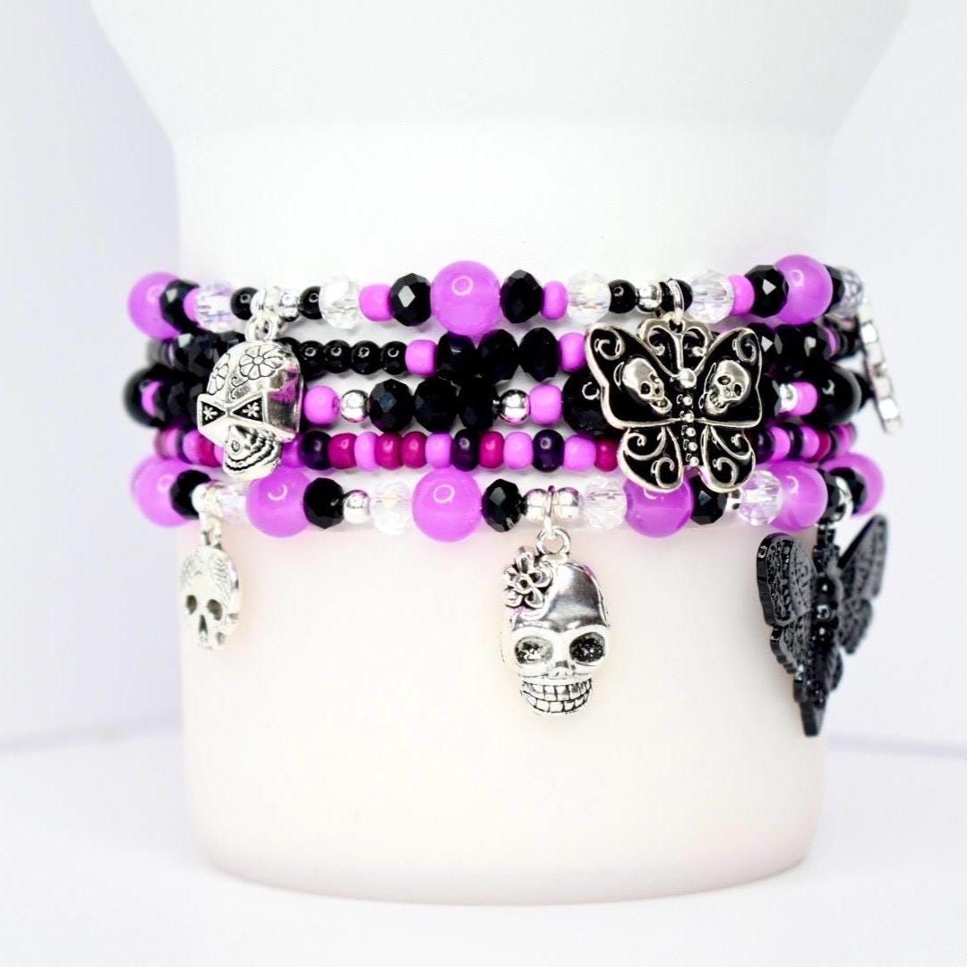 Handmade gothic tumbler bracelet stack with purple and black beads – skull and bat charm bracelet for unique goth accessories and drinkware decor.