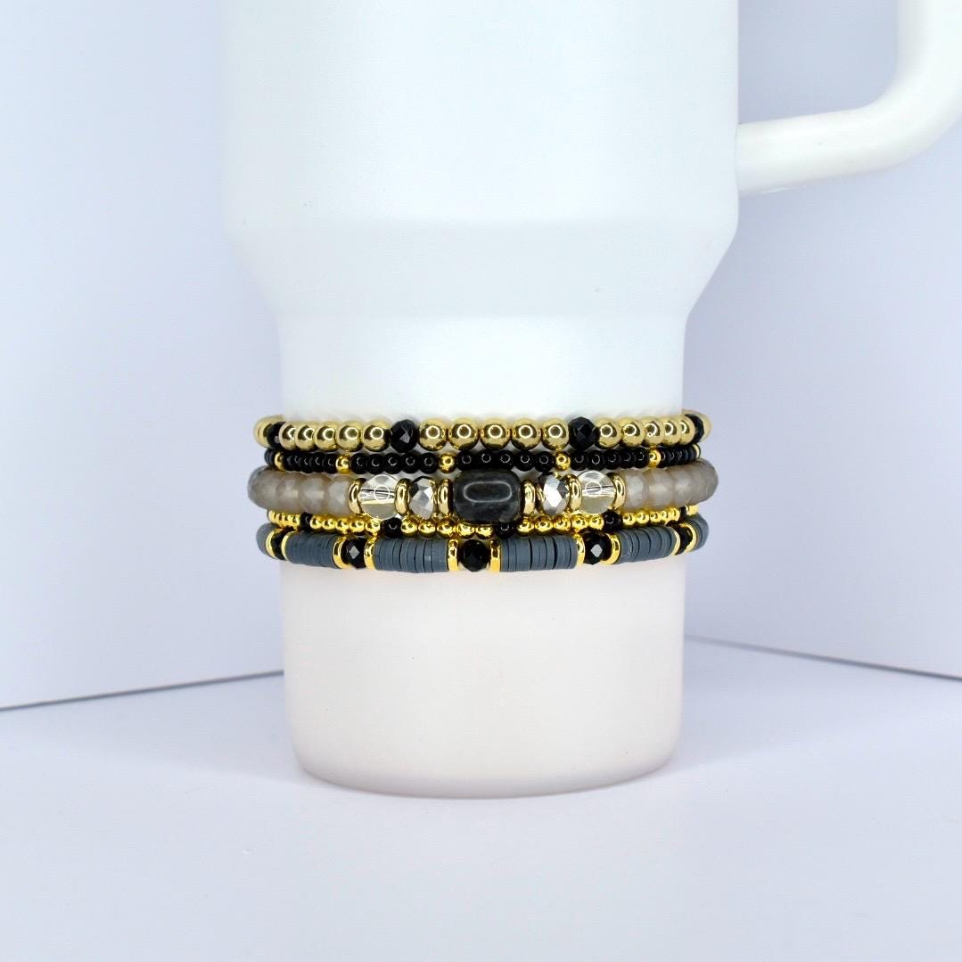 Beaded tumbler bracelet in black, gold, and gray – stylish cup wrap accessory for everyday use.