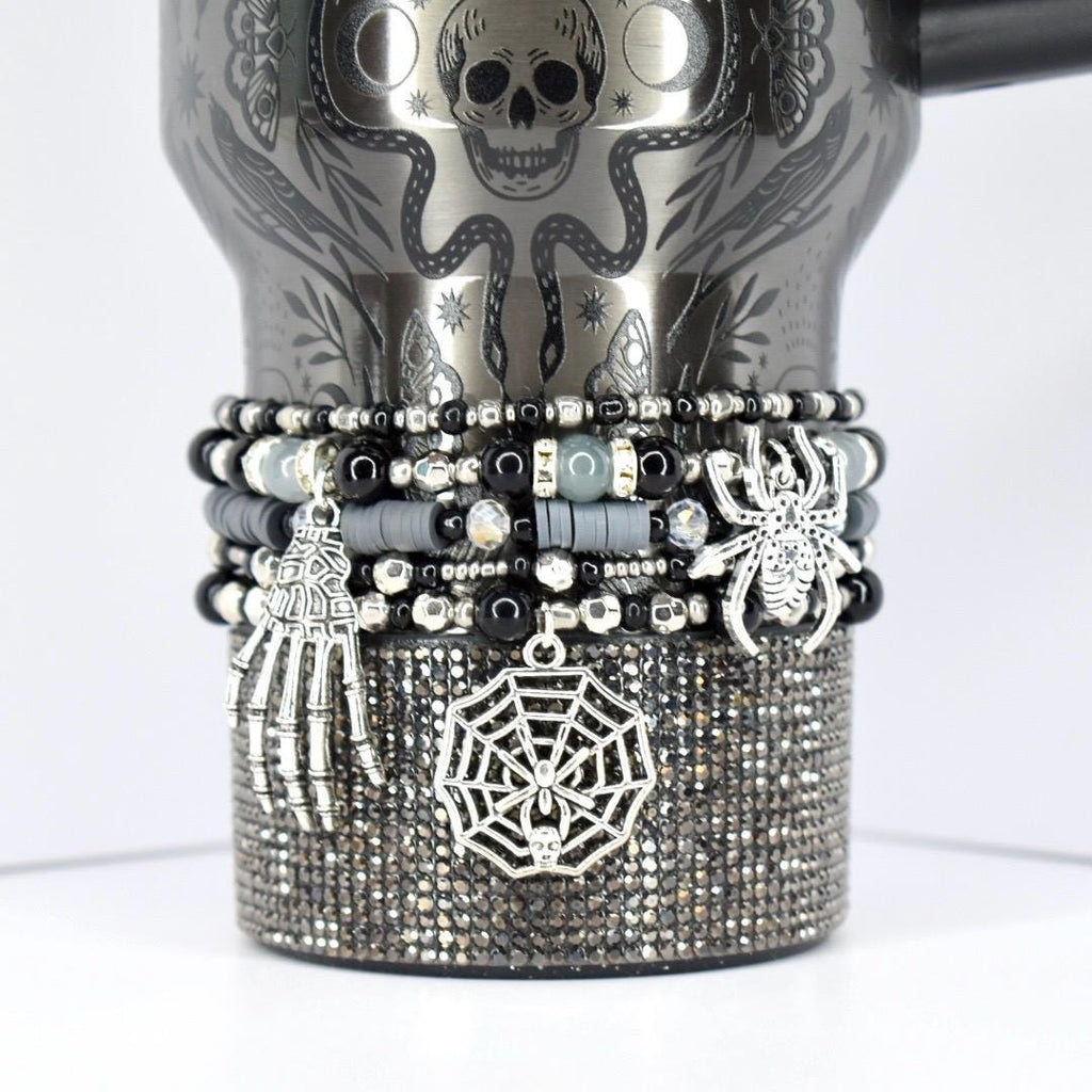 Halloween tumbler bracelet in black and silver with spider, web, and skeleton hand charms – spooky beaded wrap for gothic and seasonal drinkware.