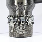 Halloween tumbler bracelet in black and silver with spider, web, and skeleton hand charms – spooky beaded wrap for gothic and seasonal drinkware.
