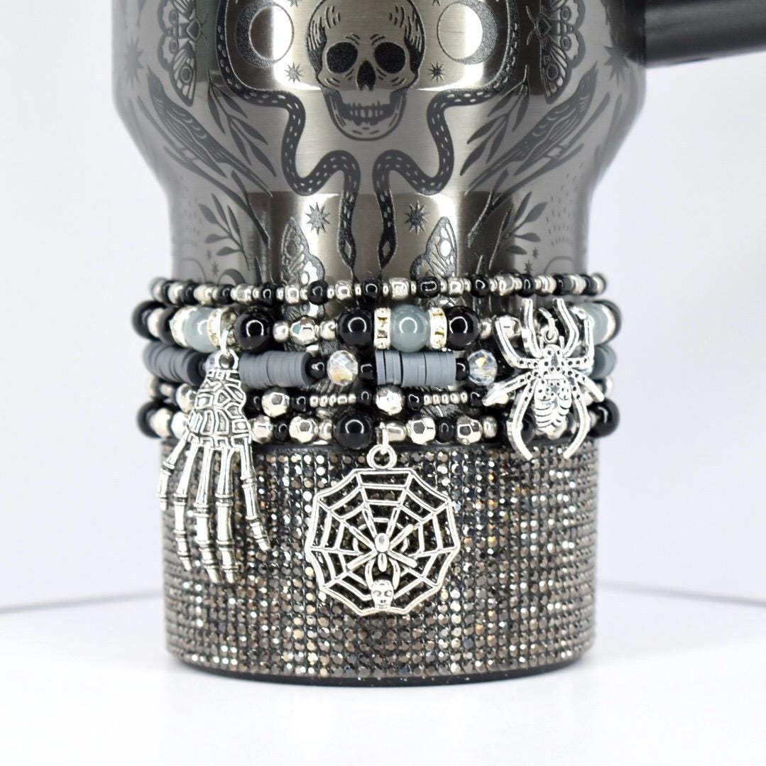 Halloween tumbler bracelet in black and silver with spider, web, and skeleton hand charms – spooky beaded wrap for gothic and seasonal drinkware.