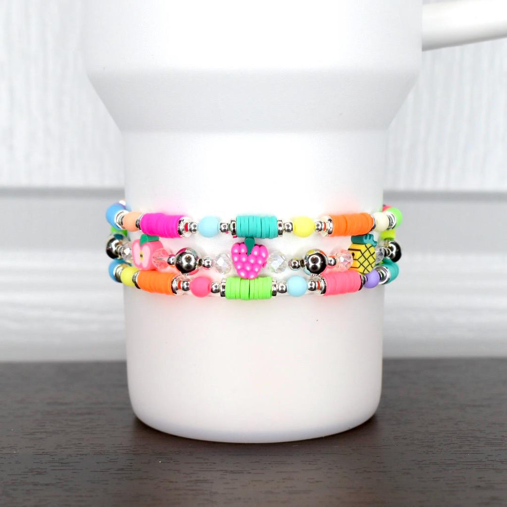 Summer tumbler bracelet with neon beads and fruit charms – strawberry, pineapple, and apple beaded wrap for colorful drinkware accessories.