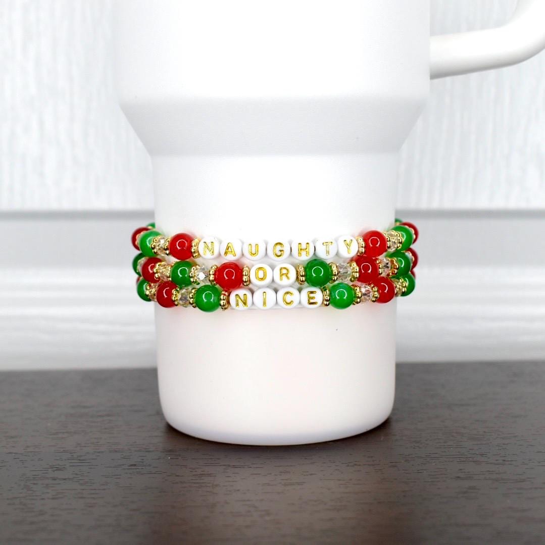 Playful Christmas tumbler bracelet set of 3 – red, green, and gold beads with ‘Naughty or Nice’ message, perfect holiday drinkware accessory.