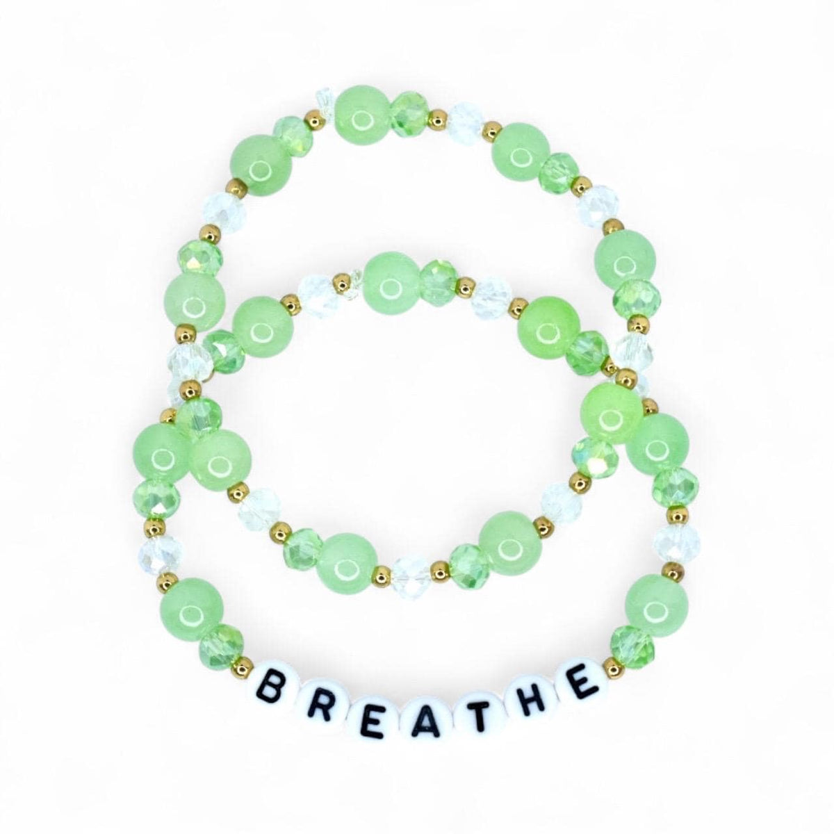 Two beaded bracelets with green and clear beads, and gold accents. The bottom bracelet spells out the word "BREATHE" in white letter beads. The bracelets are on a white background.