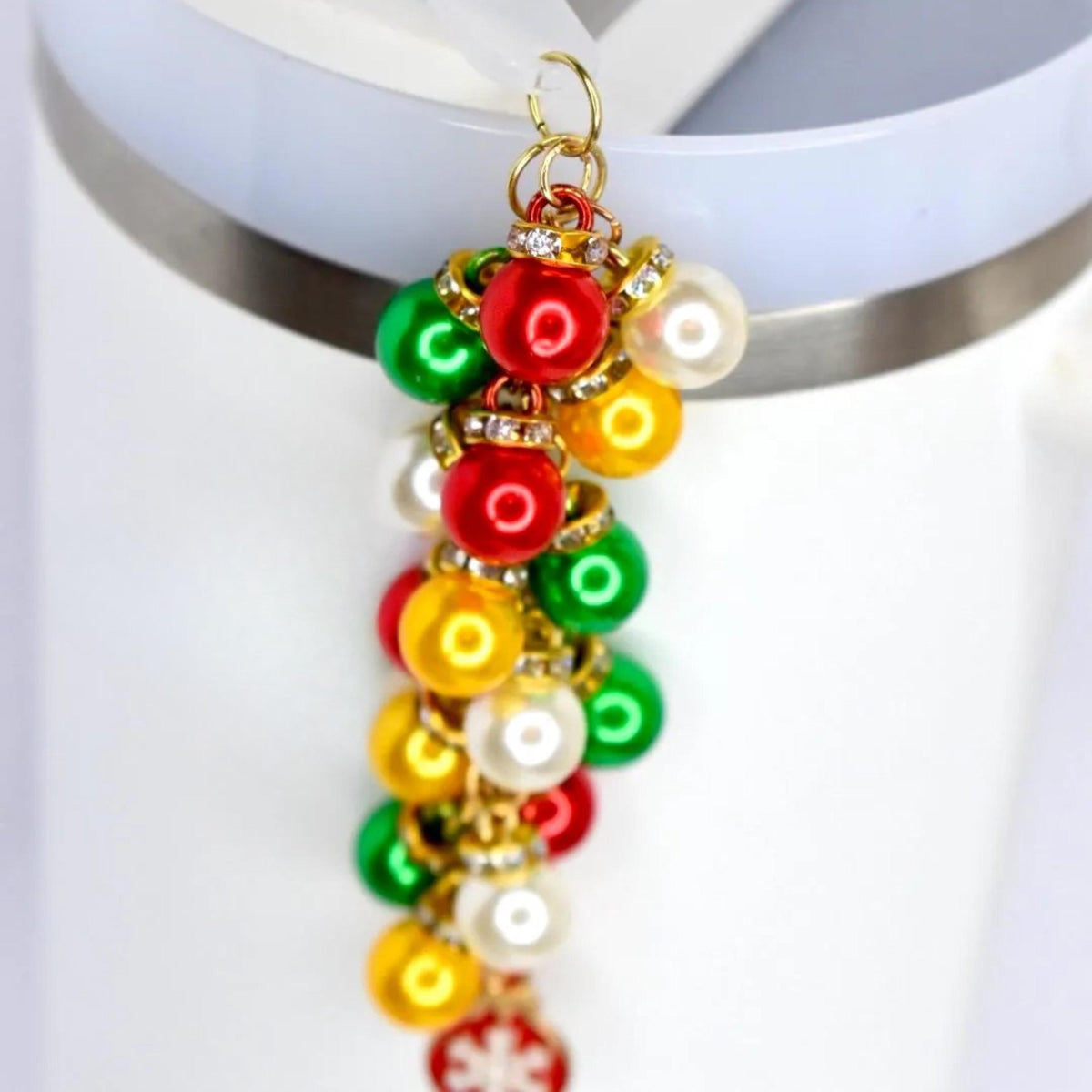 A festive charm featuring a cluster of colorful, round ornaments in red, green, yellow, and white. Each ornament is accented with a gold-colored cap and sparkling rhinestones. The charm is attached to a gold-colored loop, perfect for holiday-themed accessories.