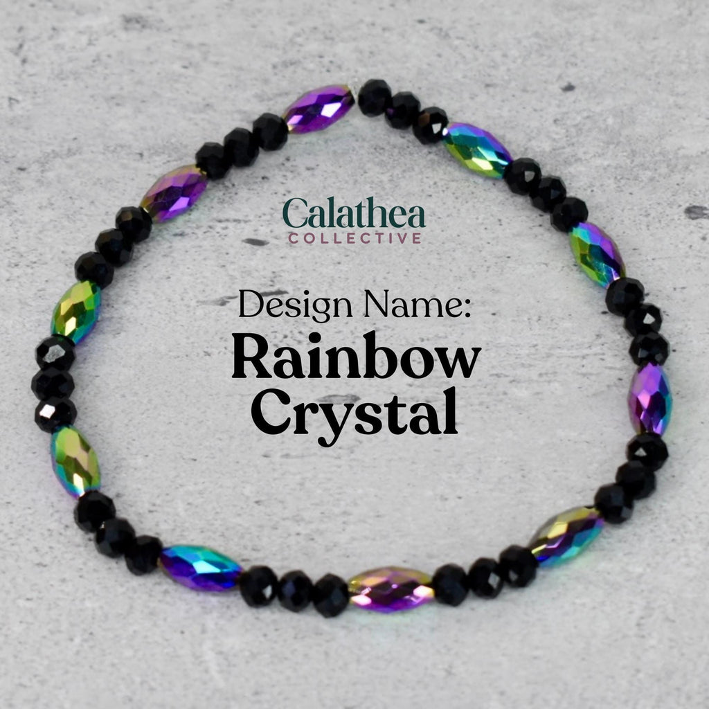 A beaded bracelet with black and iridescent rainbow-colored crystals. The bracelet is labeled "Design Name: Rainbow Crystal" and features the "Calathea Collective" logo. The crystals are oval-shaped and interspersed with smaller black beads.