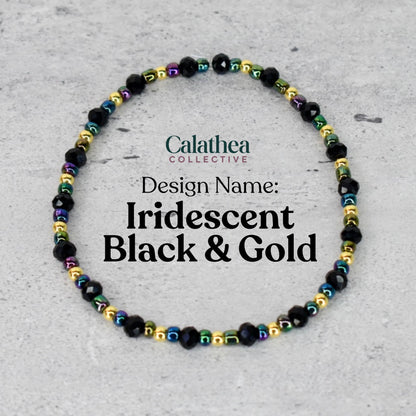 A beaded bracelet with black, iridescent, and gold beads. The bracelet is labeled "Iridescent Black & Gold" and is from the "Calathea Collective" design. The beads are strung together to form a circular shape.