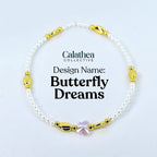 A delicate bracelet featuring small white beads, gold-colored accents, and a pink butterfly charm. The text "Calathea Collective" and "Butterfly Dreams" are displayed on the image.