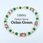A beaded bracelet with the text "Calathea Collective" and "Ozian Green." The bracelet features clear, pink, green, and gold beads. The design includes star-shaped and round beads, with a mix of clear and pink crystal accents.