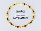 A gold-colored beaded bracelet with red and white beads. The bracelet is circular and features the text "Love Letters" and the Calathea Collective logo.