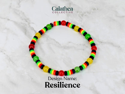 A beaded bracelet with red, yellow, green, and black beads. The bracelet is labeled "Resilience" and is from the Calathea Collective. The beads are arranged in a pattern of alternating colors.