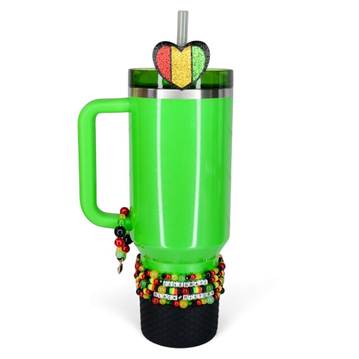 A bright green tumbler with a handle, adorned with a heart-shaped glitter accent in red, yellow, and green. The tumbler is decorated with beaded bracelets and the words "Celebrate Black History". Includes a straw.