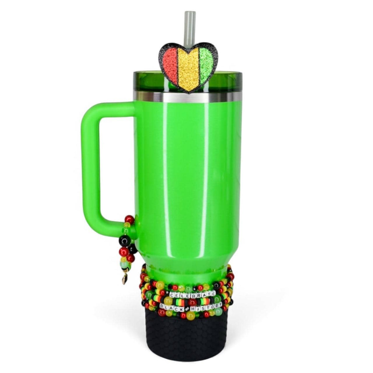 A bright green tumbler with a handle, adorned with a heart-shaped glitter accent in red, yellow, and green. The tumbler is decorated with beaded bracelets and the words "Celebrate Black History". Includes a straw.