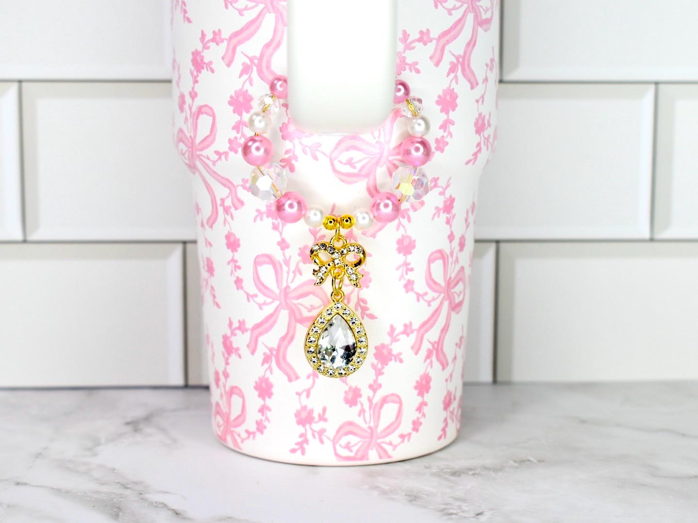 Elegant gold bow charm with teardrop crystal centerpiece on pearl and bead bracelet feminine jewelry accessory