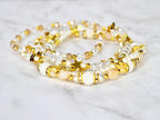 a set of five gold and pearl handmade beaded bracelets featuring star beads, clear crystal beads, and sparkling beige beads. bracelet design inspired by the starlight shimmer Stanley.
