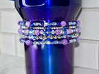 A deep blue tumbler with a gradient finish, adorned with multiple rows of beaded embellishments. The beads are a mix of purple, silver, and blue, creating a sparkling, decorative effect. The tumbler is designed for beverages.