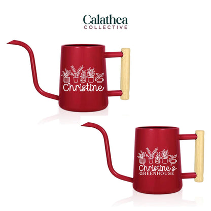 Two red metal watering cans with long spouts and wooden handles. Each can has a white graphic of plants and the name "Christine" or "Christine's Greenhouse". The cans are designed for indoor or outdoor gardening.