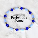 A bracelet with the design name "Periwinkle Peace". The bracelet features light blue disc-shaped beads, interspersed with dark blue spherical beads and silver-colored decorative elements. The bracelet is displayed on a white surface.