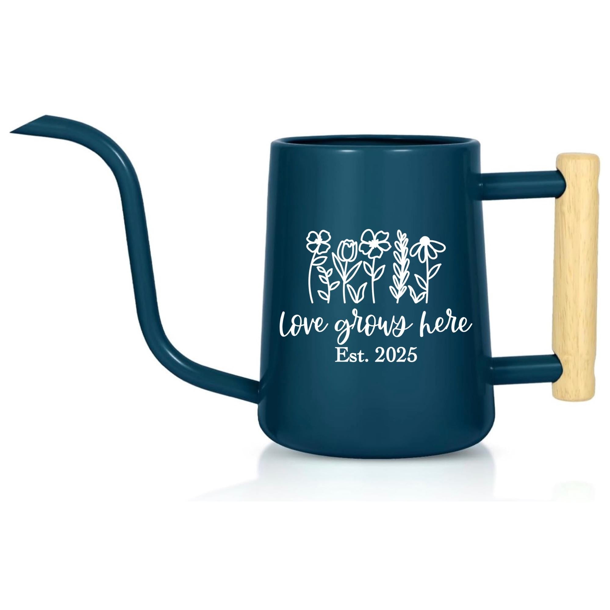 A dark blue watering can with a long, curved spout and a wooden handle. The can features a white floral design and the text "love grows here Est. 2025".