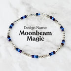 A delicate beaded bracelet featuring small silver beads interspersed with blue and purple beads. The text "Design Name: Moonbeam Magic" is displayed in black font.