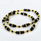 Two beaded bracelets. The bracelets feature black beads interspersed with gold-colored beads and gold-colored spacers with clear rhinestones. The bracelets are displayed on a white background.