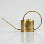 A gold metal watering can with a long spout and a curved handle. The can features a black floral design and the name "Amanda" in script. The watering can is designed for indoor or outdoor plant care.
