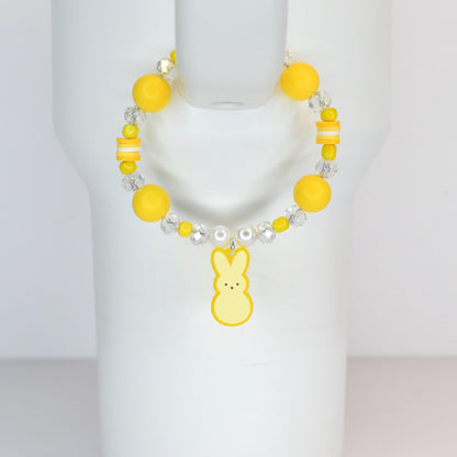 A yellow beaded bracelet with a bunny charm. The bracelet features large yellow beads, clear crystal beads, and a yellow bunny charm. The bracelet is displayed on a white surface.